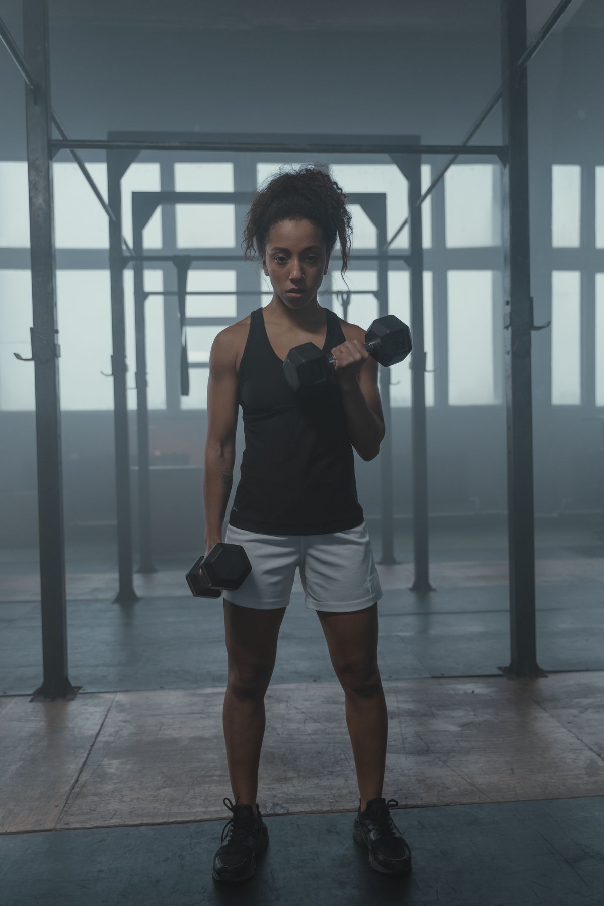 Mujer entrenando con mancuerna, enfocada