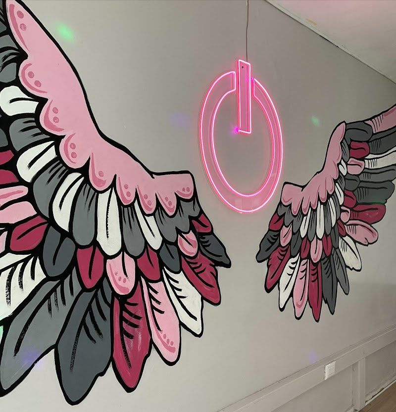 Mural de alas rosa en Emotion Girls Club NC