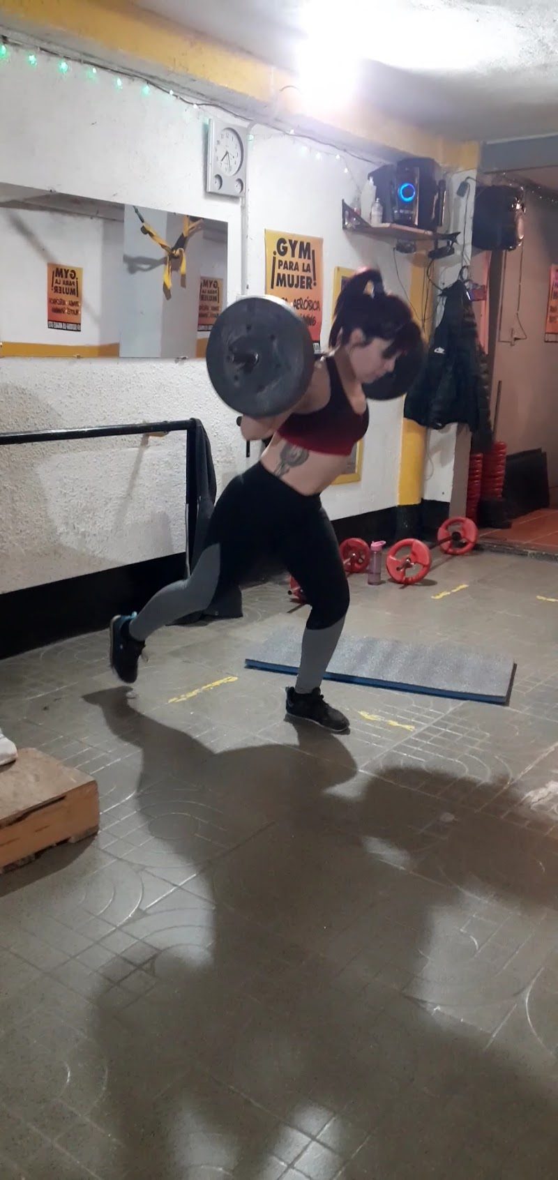 Alumna entrenando junto al cartel GYM PARA LA MUJER