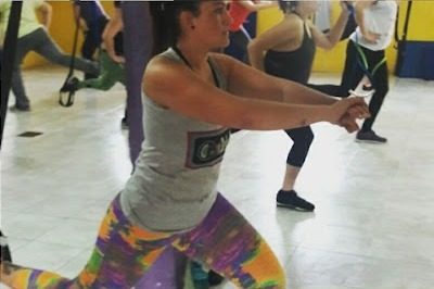 Mujer entrenando con bandas TRX en ONA GYM